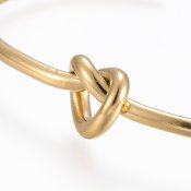 Rostfritt stål - öppet guldfärgat, stelt armband med knut